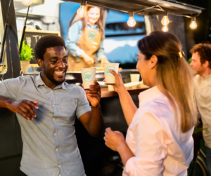 Two people cheers their custom printed coffee cups