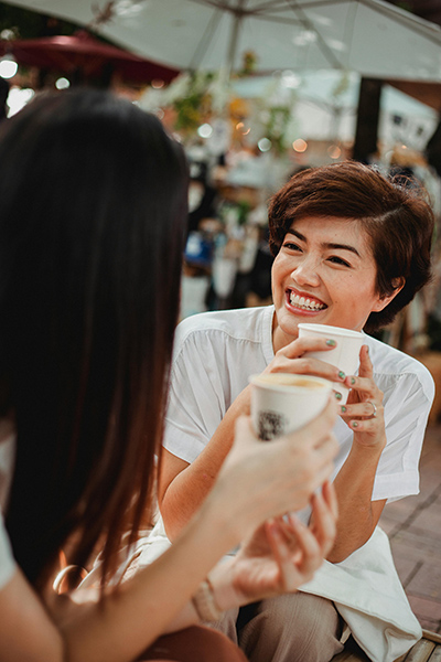 Two women share a moment while enjoying some coffee.